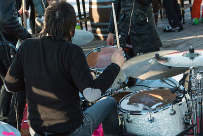 Rear view of man playing music outdoors