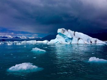 Scenic view of iceberg against sky during winter