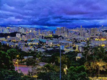 Illuminated cityscape against blue sky