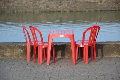 Red chairs on deck chair by water