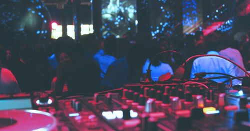 Close-up of sound mixer against crowd at music concert