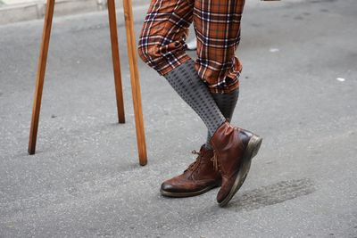 Low section of person wearing shoes while standing on road