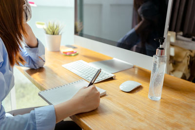 High angle view of woman using laptop on table