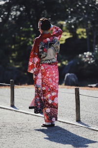 Rear view of woman walking on road