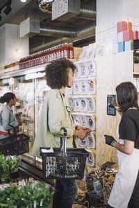 Saleswoman assisting male customer with digital tablet at store