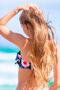 Rear view of young woman in bikini at beach