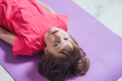 High angle view of young woman lying on bed at home