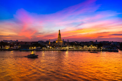 River with buildings in background at sunset