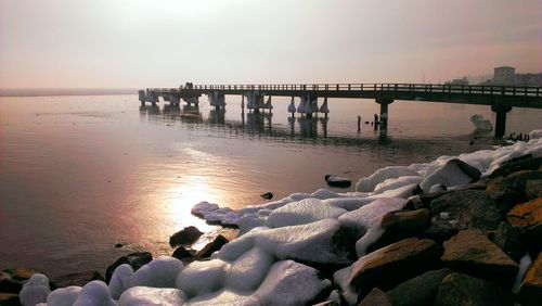 Pier on sea at sunset