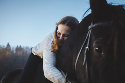 Close-up of woman hugging horse