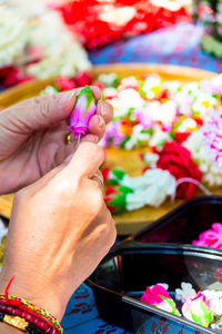 Close-up of hands making floral garland