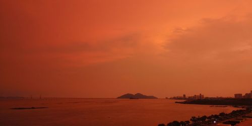 Scenic view of sea against orange sky