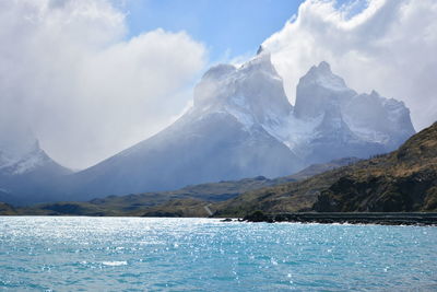 Scenic view of sea and mountains against sky