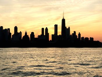 Silhouette of buildings in city during sunset