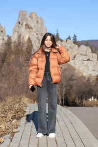 Portrait of a girl in a jacket on a mountain background.