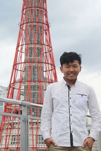 Portrait of young man standing against sky