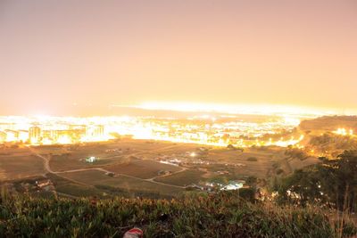 High angle view of illuminated cityscape against clear sky