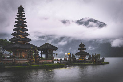 Pura ulu danau temple by lake against cloudy sky