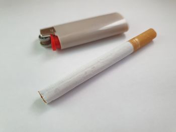 High angle view of cigarette on table against white background