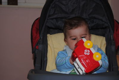 Portrait of cute boy with toy at home