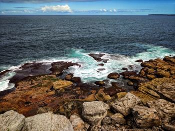 Scenic view of rocks in sea against sky