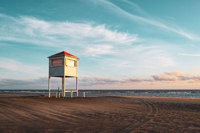 Lifeguard hut on beach against sky