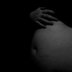 Close-up of human hand against black background