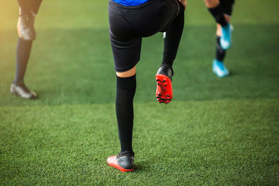 Low section of people running on soccer field