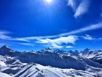 Scenic view of snowcapped mountains against blue sky