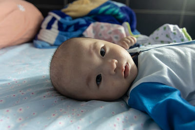 Portrait of cute baby lying on bed