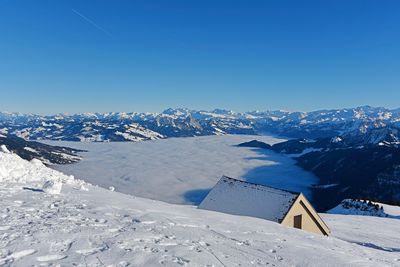 Scenic view of snowcapped mountains against clear blue sky