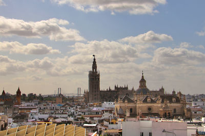 Buildings in city against cloudy sky