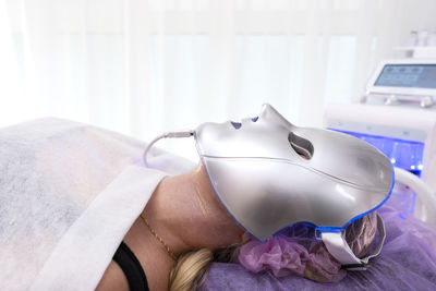 Beautiful woman with led mask. skin rejuvenation facial mask for healthy skin. beauty procedure.