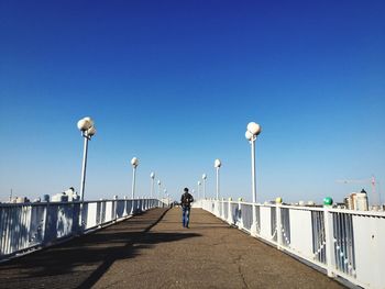 People walking on street against clear sky