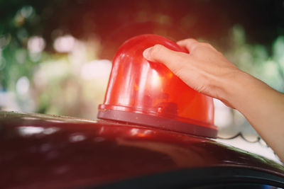 Close-up of hand holding red glass