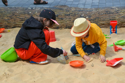 Boy and girl playing on the beach on summer holidays. children building a sandcastle