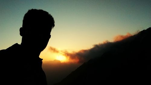 Silhouette man standing against sky during sunset