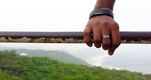 Close-up of hands against sky