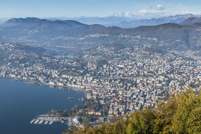 Aerial view of townscape and mountains against sky