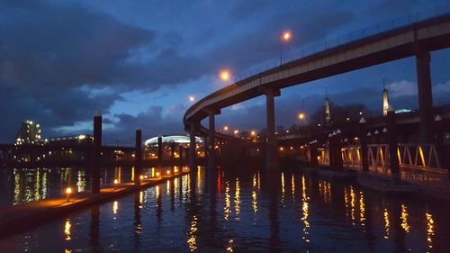 Illuminated bridge over river at night