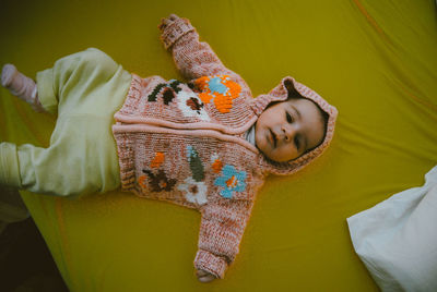 Portrait of cute baby boy sleeping on yellow bed