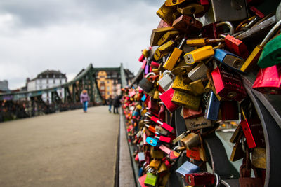 Close-up of padlocks on railing against bridge