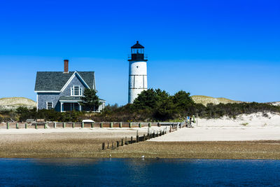 Building by sea against clear blue sky