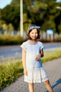 Portrait of girl standing on footpath in park