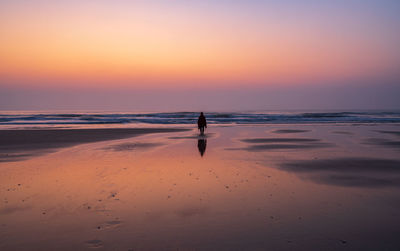 A person stand alone on the beach in sunrise