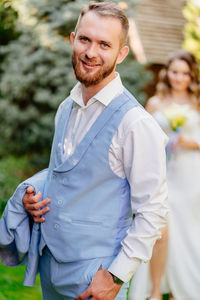 Portrait of groom with bride outdoors