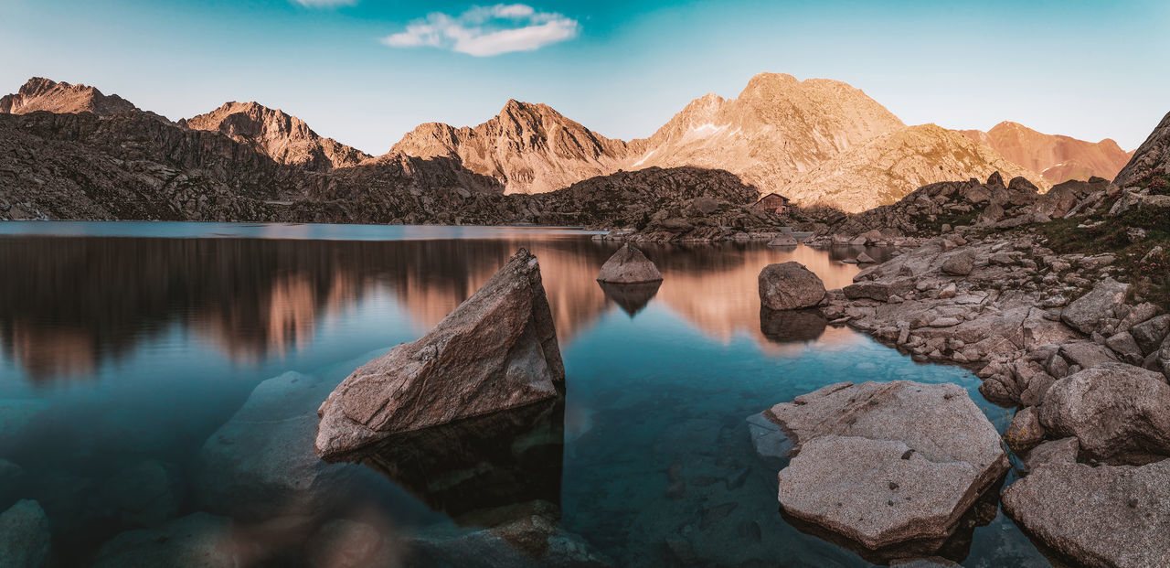 water, mountain, rock, scenics - nature, tranquil scene, solid, tranquility, rock - object, sky, beauty in nature, non-urban scene, nature, idyllic, mountain range, no people, lake, rock formation, geology, day, outdoors, eroded, formation