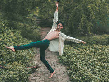 Full length of young man with arms raised