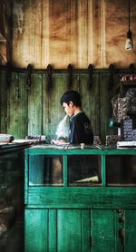 Woman looking away while sitting on table