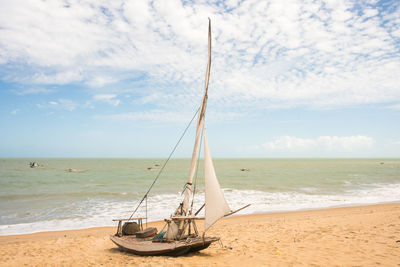 Sailboat on beach against sky